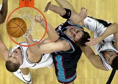 Gasol lucha con los defensas de los San Antonio Spurs Rasho Nesterovic y Hedo Turkoglu.