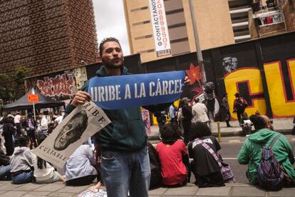 Personas protestan en contra del expresidente colombiano, durante su audiencia en Bogotá, este lunes.