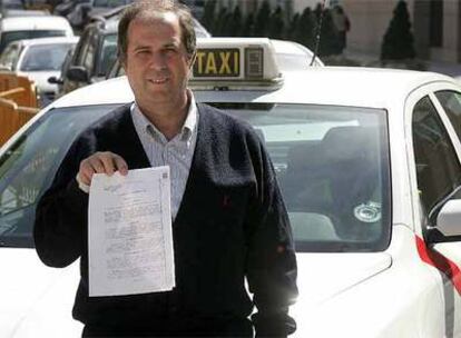 José Artur sostiene, ante su taxi, la sentencia absolutoria.