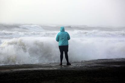 Una mujer observa el mar agitado por las olas en Abeystwyth, al oeste de Gales. Algunas comunidades de Gran Bretaña están bajo alerta roja por amenazas de rachas de viento de más de 150 kilómetros por hora.