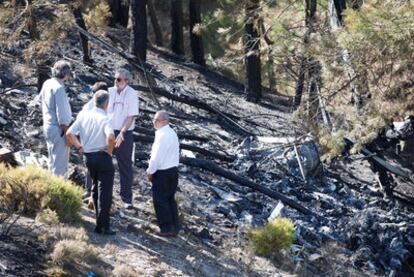 Técnicos de Aviación Civil inspeccionan los restos del helicóptero siniestrado.