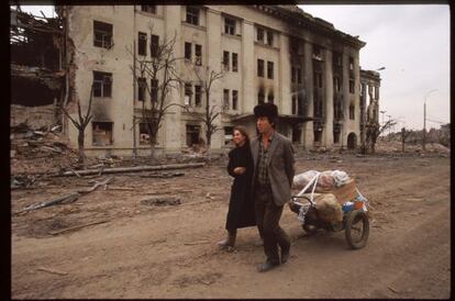 Una pareja atraviesa la devastada Grozny, la capital de Chechenia, en 1995.