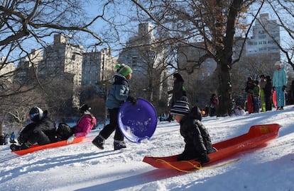 Varios ni&ntilde;os se deslizan por las laderas de Central Park en Nueva York. 