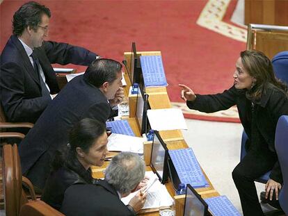 La conselleira de Vivenda, Teresa Táboas, charla con diputados del Grupo Popular durante el pleno del Parlamento de ayer.