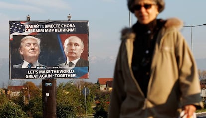 Una mujer pasa frente a un cartel que representa a Donald Trump y Vladimir Putin en Danilovgrad (Montenegro).