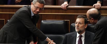 El ministro de Justicia, Alberto Ruiz-Gallardón, saluda al presidente, Mariano Rajoy, quien ha acudido al Congreso, pero ha delegado en Montoro la explicación de las medidas de ajuste del Ejecutivo.