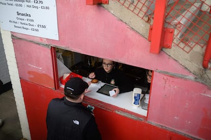 Un aficionado del Wrexham compra un pastel en uno de los puestos de Racecourse Ground, al descanso del partido de su equipo ante el Maidenhead United.