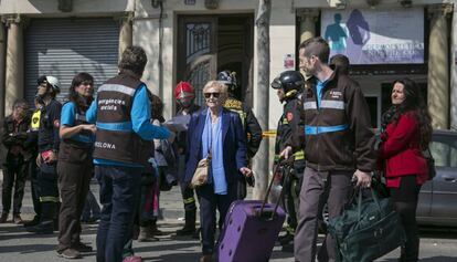 Una vecina de uno de los edificios afectadosdea la calle Llull se acompañada por los servicios sociales del Ayuntamiento.