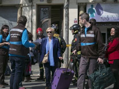 Una vecina de uno de los edificios afectadosdea la calle Llull se acompañada por los servicios sociales del Ayuntamiento.