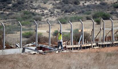 Un operario marroquí trabaja en la construcción de una valla en la frontera con Argelia el mes de agosto. / Fadel Senna (AFP)