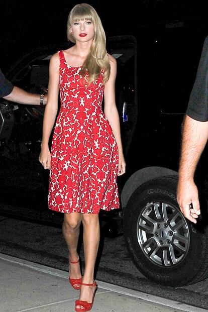 Taylor Swift se ha convertido en todo un icono de estilo. La cantante mezcla su aire country con la elegancia que se respiraba en los años 50. En la foto lleva vestido lady estampado y sandalias con mini lazo ambos en rojo.