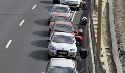 Varios israelíes, en una autopista mientras suena la alarma antiaérea en Tel Aviv