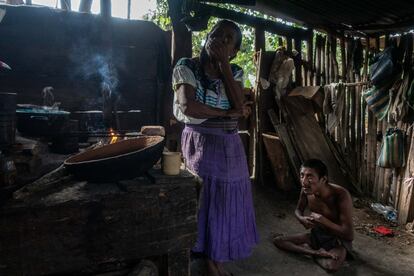 Sebastiana Alvarado Guzmán, de 67 años, en la cocina de su casa en Chilón. A sus pies está Pablo, su hijo de 33 años, discapacitado. El hombre no puede caminar, se arrastra, no habla y reclama la atención de la madre con gritos. Sebastiana no sabe decir qué es lo que sufre.