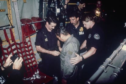 El exgeneral Manuel Noriega es esposado por miembros de la DEA a bordo de un avión de transporte, el 4 de enero de 1990.