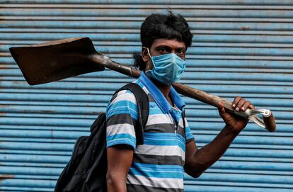Un trabajador migrante se va a trabajar después de que se levantaran algunas restricciones contra la covid-19 en Kochi, India.