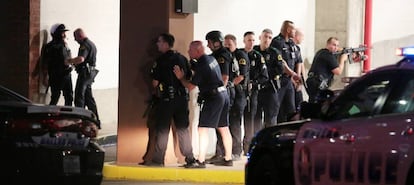 Agentes de la policía de Dallas se protegen durante el tiroteo.
