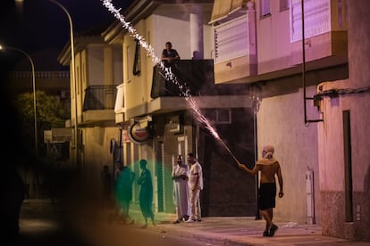 Un encapuchado lanza una bengala en el barrio de San Antonio en Torre Pacheco, Murcia, esta madrugada.