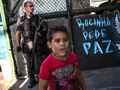 Uma criança e um policial na quadra onde moradores da Rocinha pediram à volta da sua rotina.