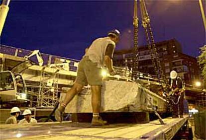 Dos operarios iniciaban anoche el desmontaje del paso elevado de Santa María de la Cabeza.