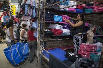 Una mujer apila mercanc&iacute;a en un comercio del mercado de La Salada, el pasado jueves.