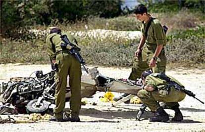 Soldados israelíes analizan los restos de la avioneta derribada ayer.