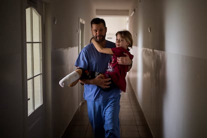 Yana Stepanenko, de 11 años, llevada por un médico en un hospital público de Lviv, Ucrania, el pasado 13 de mayo. Yana y su madre, de 43 años, resultaron heridas durante el bombardeo a la estación de tren de Kramatorsk. Viajaban junto a Karik , el hermano gemelo de Yana, que salió ileso. Tenían planeado escapar hacia el oeste en busca de seguridad. 