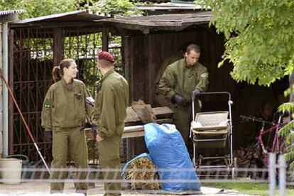 Tres policías alemanes registran el garaje donde se hallaron los cadáveres de nueve niños.