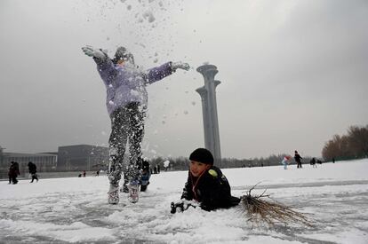 Varios niños juegan en la nieve en un canal congelado en el Parque Olímpico de Pekín. Los Juegos Olímpicos de Invierno en la capital china se inaugurarán en febrero.