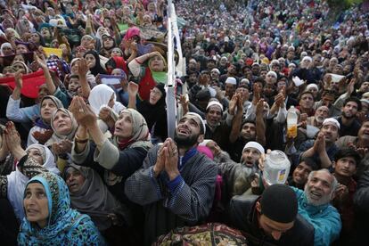 Una multitud de devotos musulmanes de Kashmiri rezan a un sacerdote jefe que muestra una reliquia sagrada que se cree que es el pelo de la barba del profeta Mohammad on Mehraj-u-Alam, en el Santuario de Hazratbal, a las afueras de Srinagar (India).