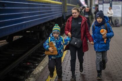 Una mujer llora mientras corre con sus dos hijos en la estación de Kiev para subirse a un tren con destino a la ciudad costera de Mariupol (sureste). Rusia ha impuesto controles en la ciudad de Jersón, de unos 290.000 habitantes. Aunque el Gobierno ucranio niega que el ejército invasor haya conquistado esta localidad del sur del país, con puerto en el mar Negro, el alcalde, Igor Kolyjayev, ha reconocido que las tropas rusas ya están en la sede del Gobierno local y recorren las calles.