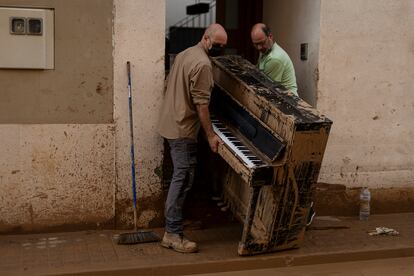 Miguel Ramírez retira de su casa un piano inutilizado por la fuerza del agua, el 5 de noviembre. El instrumento, comprado por su esposa Lupe Murcia con sus ahorros a los 17 años, tiene un gran valor sentimental. La noche de la inundación, sus hijos lograron subir otros instrumentos a la planta superior, pero no llegaron a tiempo para salvar el piano, que hasta media hora antes de la riada estaba tocando su hija.