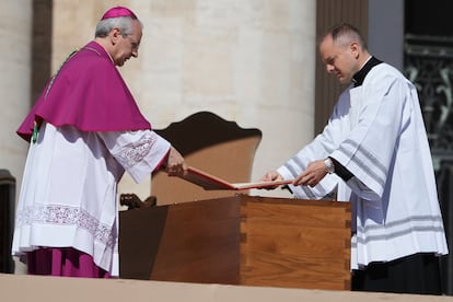 Dos oficiantes del funeral del papa Francisco colocan el Evangelio abierto sobre su féretro.
