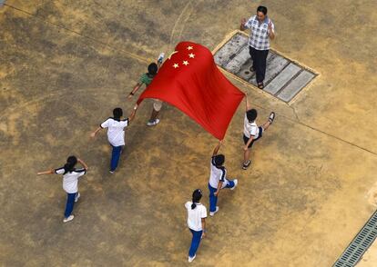 Jóvenes estudiantes ensayan un desfile con la bandera china en un colegio de Guangzhou, el 17 de octubre de 2014.
