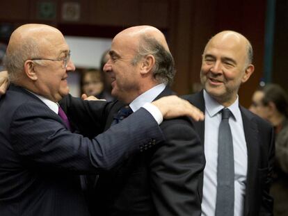 El ministro franc&eacute;s de Finanzas, Michel Sapin, saluda al espa&ntilde;ol Luis de Guindos. A la derecha, el comisario Pierre Moscovici