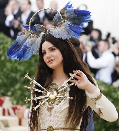 La cantante Lana Del Rey, con un diseño de Gucci, luce siete espadas clavadas en un corazón. En la cabeza lleva una aureola decorada con varias alas de ángel.