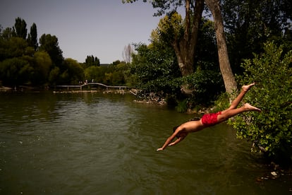 Un joven salta al río Arga para refrescarse durante la ola de calor en Pamplona este 9 de agosto.