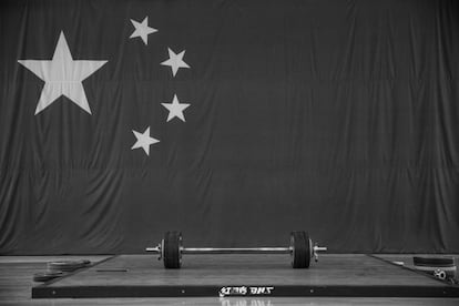 La bandera china al lado de unas pesas durante una sesión de entrenamiento preparatorio para las Olimpiadas de Río en Pekín (China).