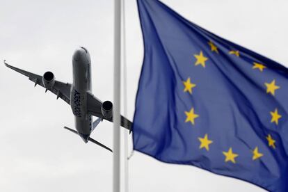 Un  Airbus vuela con una bandera de Europa en primer plano. 