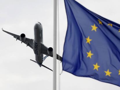 Un  Airbus vuela con una bandera de Europa en primer plano. 