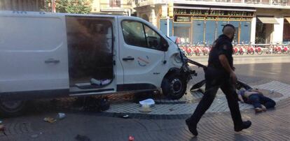 La furgoneta que causó el atentado de La Rambla junto al cuerpo de una de las víctimas.