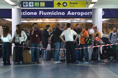 El cierre temporal del aeropuerto de Fiumicino ha causado molestias de distintos grados para los miles de pasajeros que se preparaban para viajar este jueves. Largas colas se han formado desde la madrugada en las inmediaciones del recinto aeroportuario. En la imagen, dos empleados bloquean el acceso a la terminal 3.