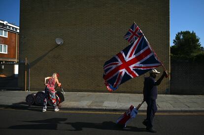Un hombre ondea una bandera mientras camina hacia el desfile principal del Carnaval de Notting Hill en el oeste de Londres (Reino Unido). Los organizadores esperan una cifra de casi un millón de asistentes entre el domingo y este el lunes en las calles del oeste de Londres, en Notting Hill, para celebrar la cultura caribeña en un carnaval considerado la mayor manifestación callejera de Europa.