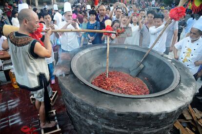 Un artista popular cocina cangrejos en el área turistica de Zhangjiajie, China. 