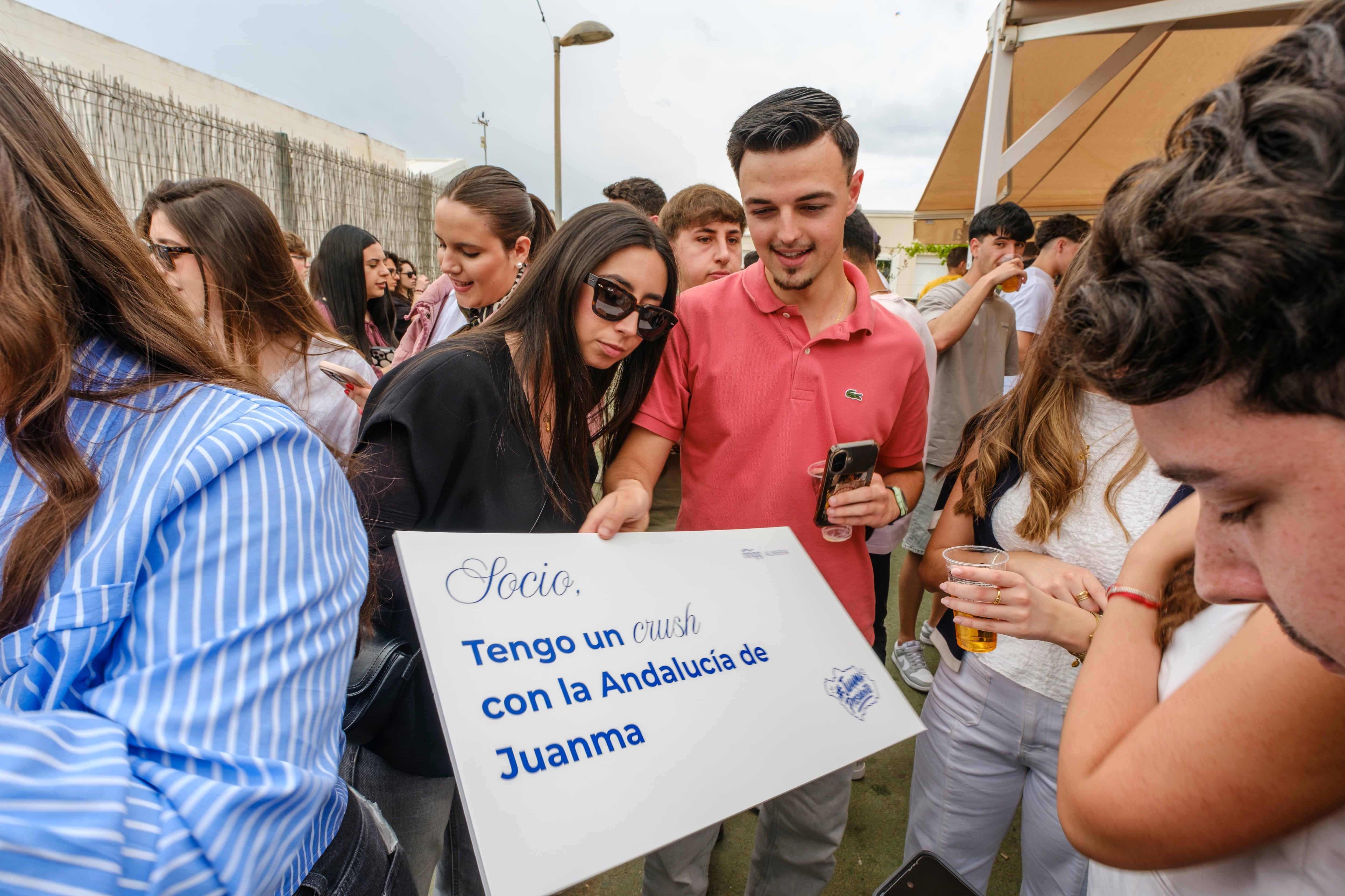 Asistentes a la barrilada en el Bar Romero de Almería. Uno de ellos muestra un cartel de apoyo a Juan Manuel Moreno, candidato del PP a la reelección como presidente de la Junta de Andalucía. 