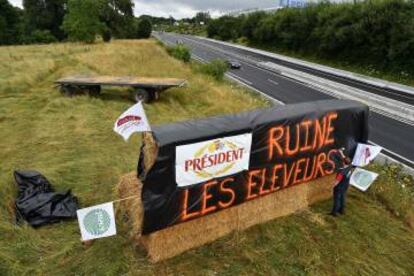Un cartel con el lema "President arruina a los ganaderos", en protesta por el bajo precio de la leche, en una carretera de Le Mans (Francia), el viernes pasado.