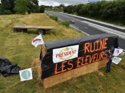 Un cartel con el lema &quot;President arruina a los ganaderos&quot;, en protesta por el bajo precio de la leche, en una carretera de Le Mans (Francia), el viernes pasado. 