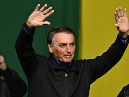 Brazilian President and re-election candidate Jair Bolsonaro greets his supporters during a rally in Santos, Sao Paulo state, Brazil, on September 27 2022. - Brazil entered the final stretch of the presidential campaign, a high voltage electoral duel between archrivals Jair Bolsonaro and Luiz In�cio Lula da Silva that, according to polls, could be defined already in the first round on October 2 in favor of the former president. (Photo by NELSON ALMEIDA / AFP)