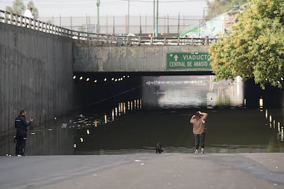 Una mujer observa el agua acumulada en el bajo puente ubicado a un costado de la estación Pantitlán.