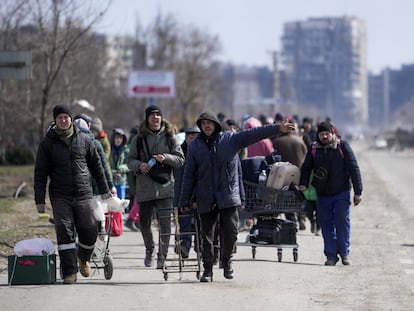 Unos civiles abandonaban la ciudad ucrania de Mariupol por un corredor humanitario, en marzo de 2022, durante el asedio de las tropas rusas.