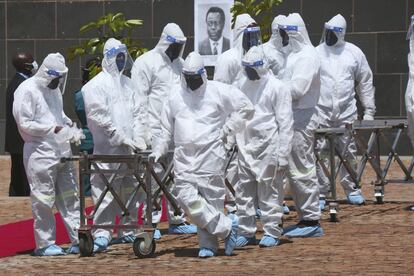 Un grupo de enterradores espera la llegada de ataúdes de fallecidos por coronavirus, en Harare (Zimbabue).